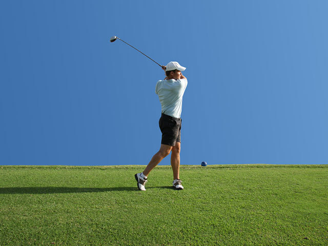 Golfspieler beim Abschlag auf dem Golfplatz